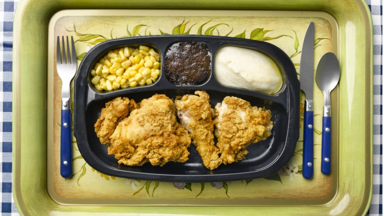 A TV dinner on a tray with cutlery